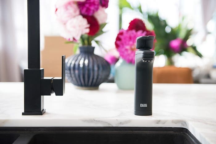 Matte Black Billi XL Dispenser on kitchen sink with flowers
